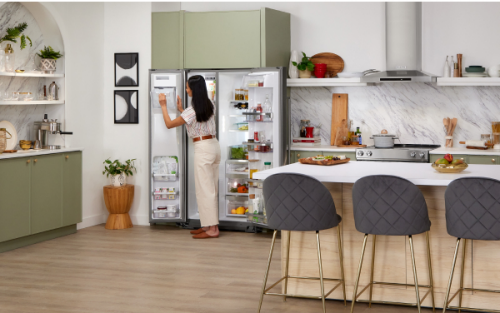 Person standing in front of an open refrigerator in a contemporary kitchen