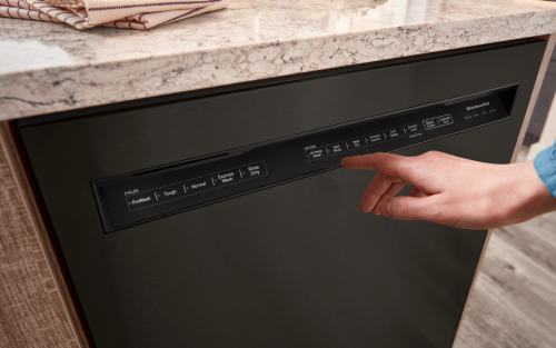 Person selecting settings on a KitchenAid® dishwasher