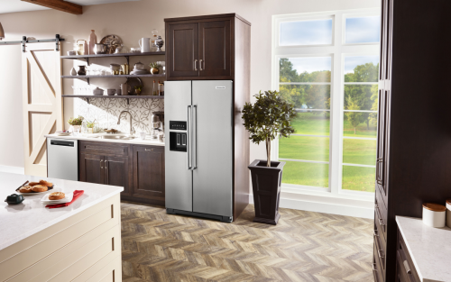 KitchenAid® side-by-side refrigerator in brown cabinetry 