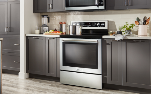 Stainless steel range in a kitchen with dark cabinets from existing article