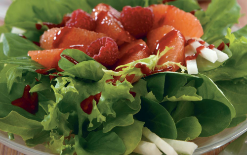 Close up of lettuce salad with fruit and vegetable toppings