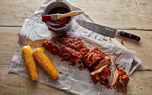 Large rack of ribs next to corn