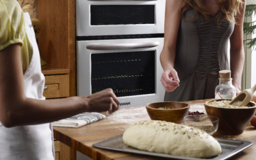 Person garnishing bread dough on a cookie sheet