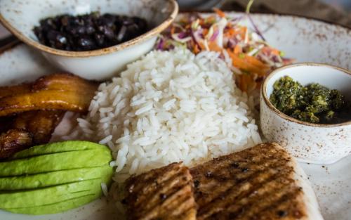 White rice on a place with sauces, vegetables and meat