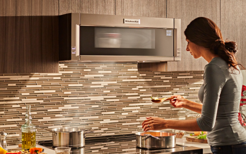 Person in front of a built-in KitchenAid® microwave