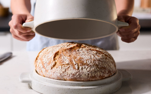 Bread in a bread bowl with person removing lid