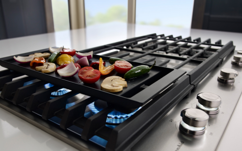 Vegetables cooking on a gas stove griddle