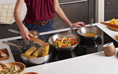 Multiple dishes cooking on a KitchenAid induction cooktop