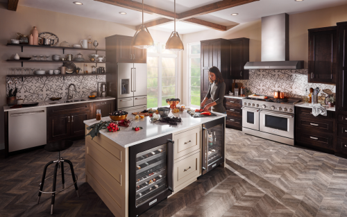 A person making a meal in a modern kitchen next to a KitchenAid® refrigerator.