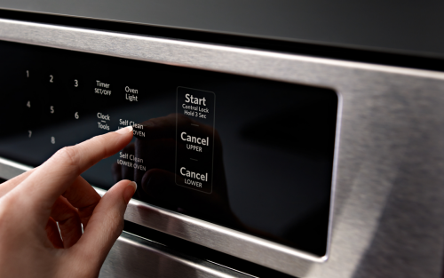 Person selecting cleaning cycle on oven