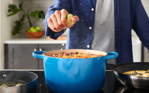 Person squeezing lime into a stock pot over the stove