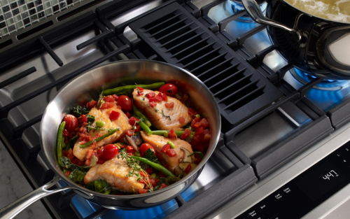 Food cooking on a downdraft gas range.