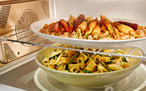 Two plates of food cooking inside a convection microwave