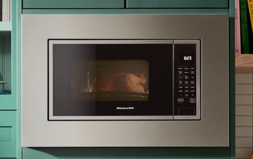 A built-in KitchenAid® microwave surrounded by teal cabinetry