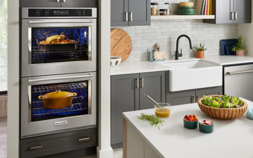 A modern kitchen with stainless steel KitchenAid® appliances and fresh food on the island