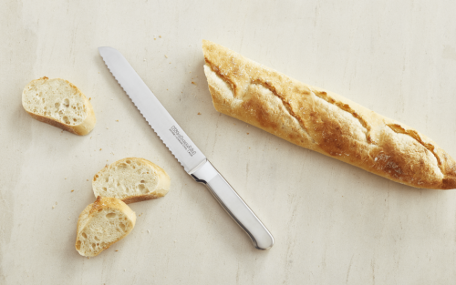 A KitchenAid® knife next to a loaf of bread.