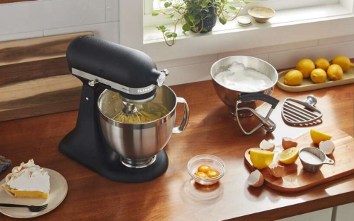 Black KitchenAid® stand mixer on countertop with various ingredients and slice of pie