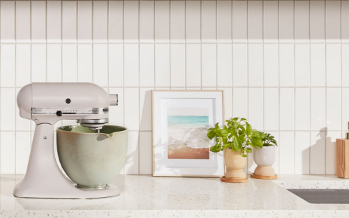  Beige KitchenAid® stand mixer with distressed green mixer bowl on granite countertop