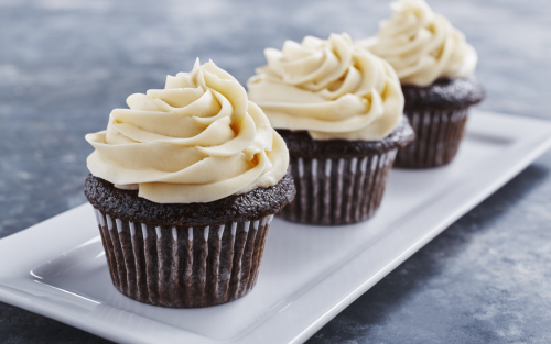 Three chocolate cupcakes topped with cream cheese frosting