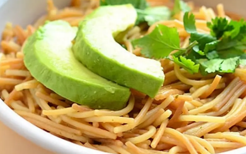 Spanish Fideo in a bowl topped with avocado slices