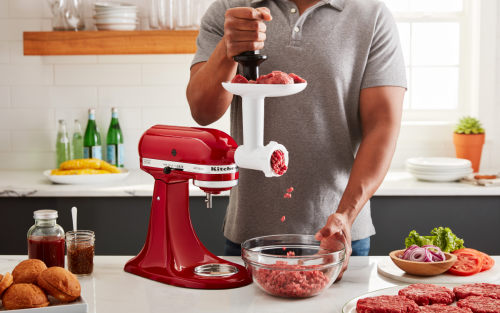 Red KitchenAid® stand mixer with Meat Grinder Attachment grinding beef