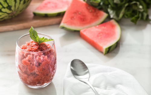 A cup of cherry shaved ice with watermelon slices