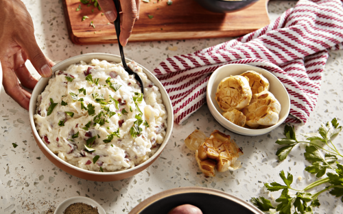 Bowls of red-skinned mashed potatoes and roasted garlic