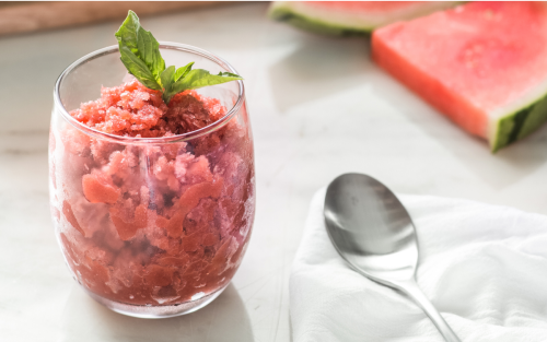 Shaved ice dessert garnished with fruit and mint