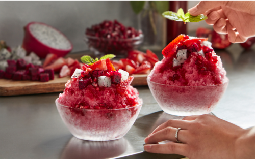 Shaved ice dessert garnished with fruit and mint