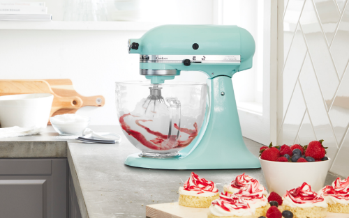 A teal KitchenAid® stand mixer with a bowl of mixed berries.