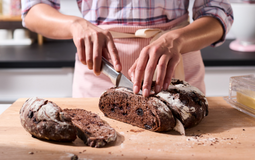 A person slicing homemade bread.