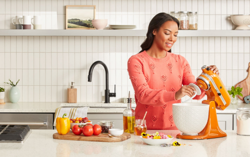 Woman placing dough hook on KitchenAid® stand mixer with white bowl