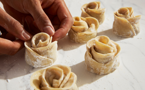 Person creating small flowers with dough