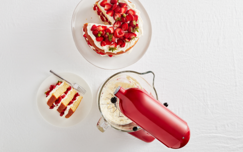 A red KitchenAid® stand mixer and a plate of strawberry shortcake.