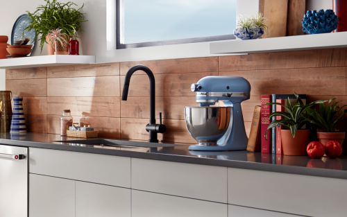 Blue KitchenAid® stand mixer on countertop with wood panel backsplash