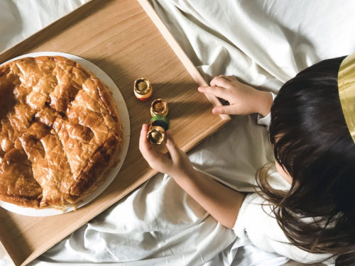 A galette des rois, or king cake, resting on a wooden tray.