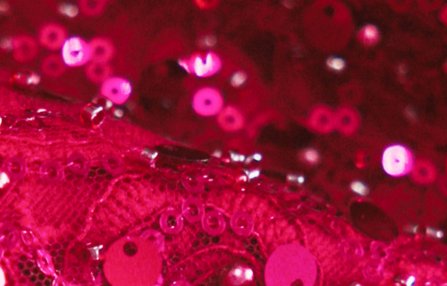 A close up macro detail shot of pink lace and sequins.