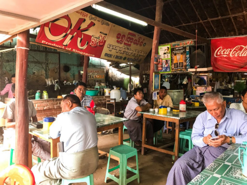  A local eatery in Myanmar filled with guests sitting on stools.