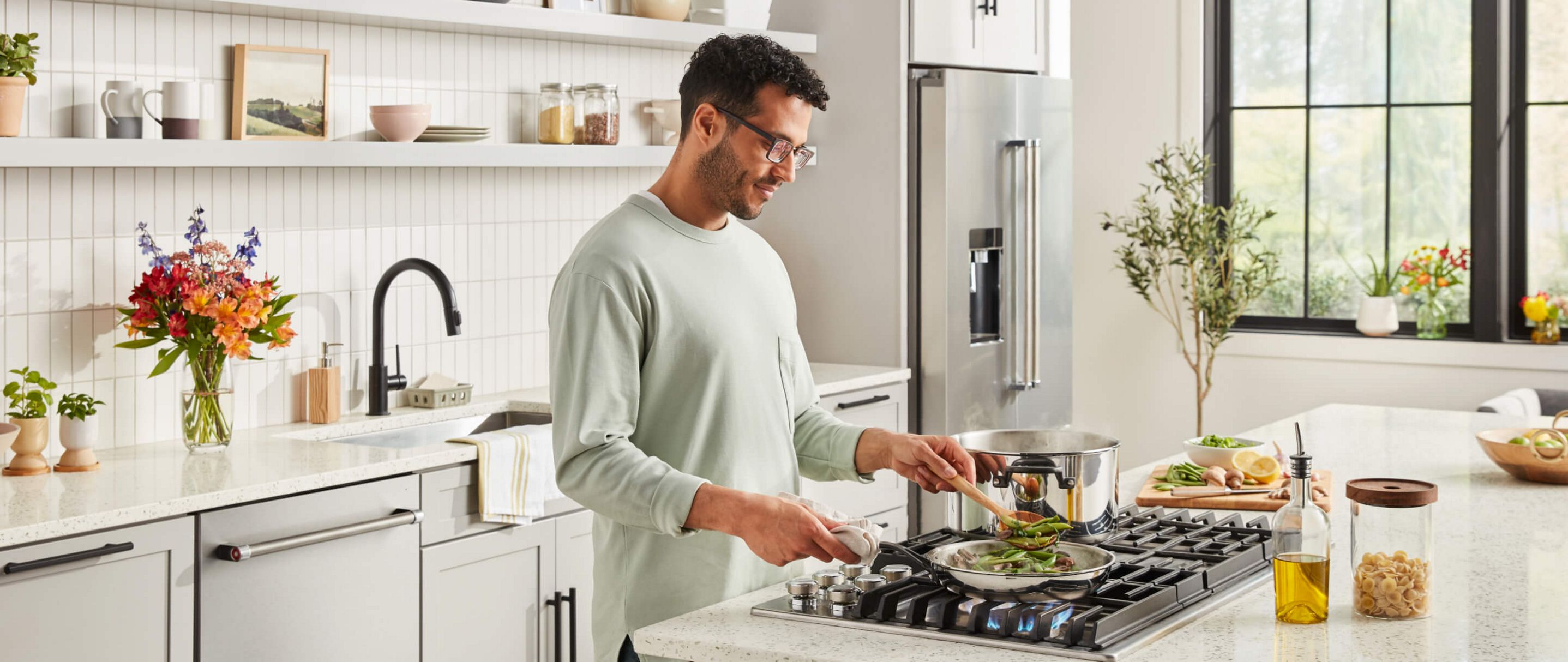 A person cooking over a cooktop.