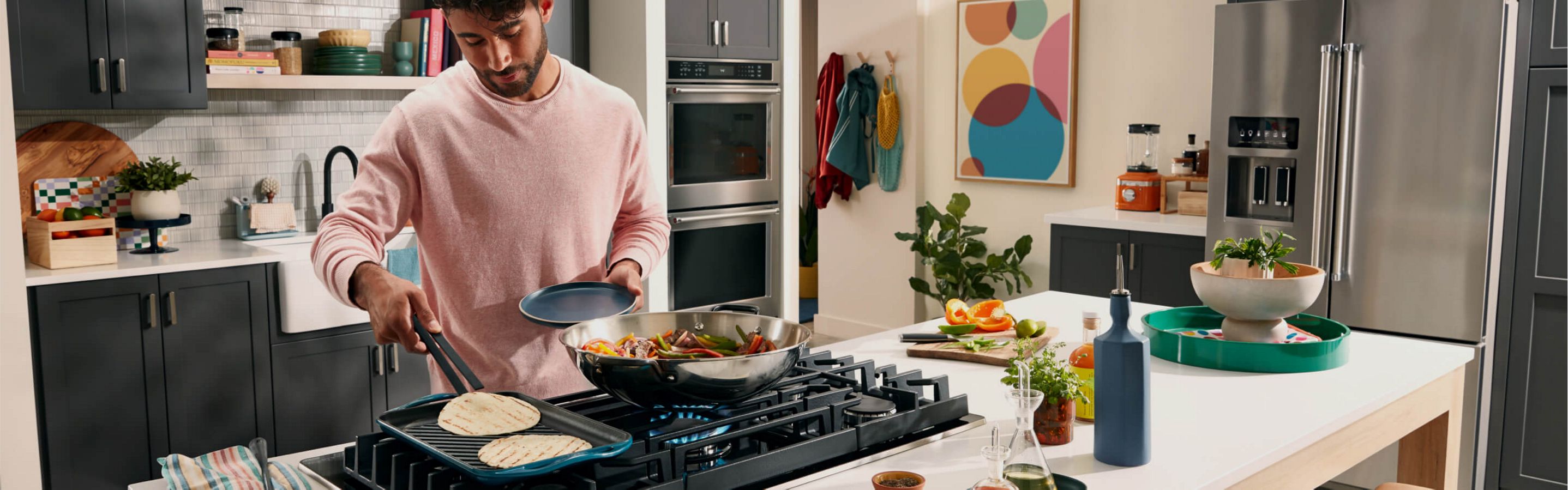 A person cooking fajitas on a KitchenAid® cooktop.