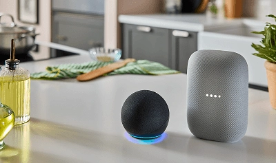 An Amazon Alexa and Google Home sitting on a countertop.