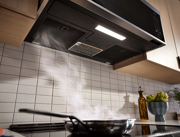A KitchenAid® Over-the-Range Microwave whisking steam away from the cooktop.