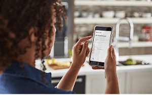 A person controlling their KitchenAid® Range with their smartphone