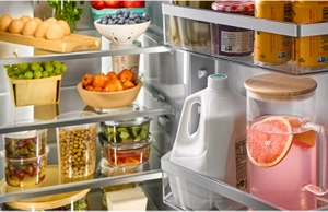 A KitchenAid® refrigerator with fully stocked glass shelves and bins