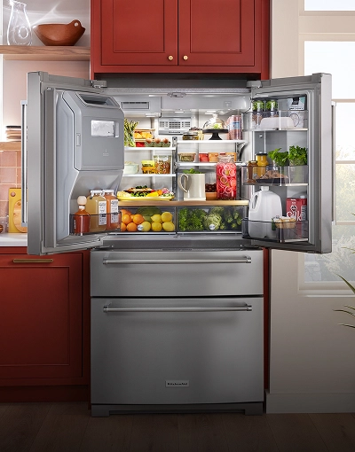A large KitchenAid® refrigerator fully stocked with fresh ingredients and packaged food items