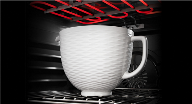 A KitchenAid® ceramic bowl placed in an oven.