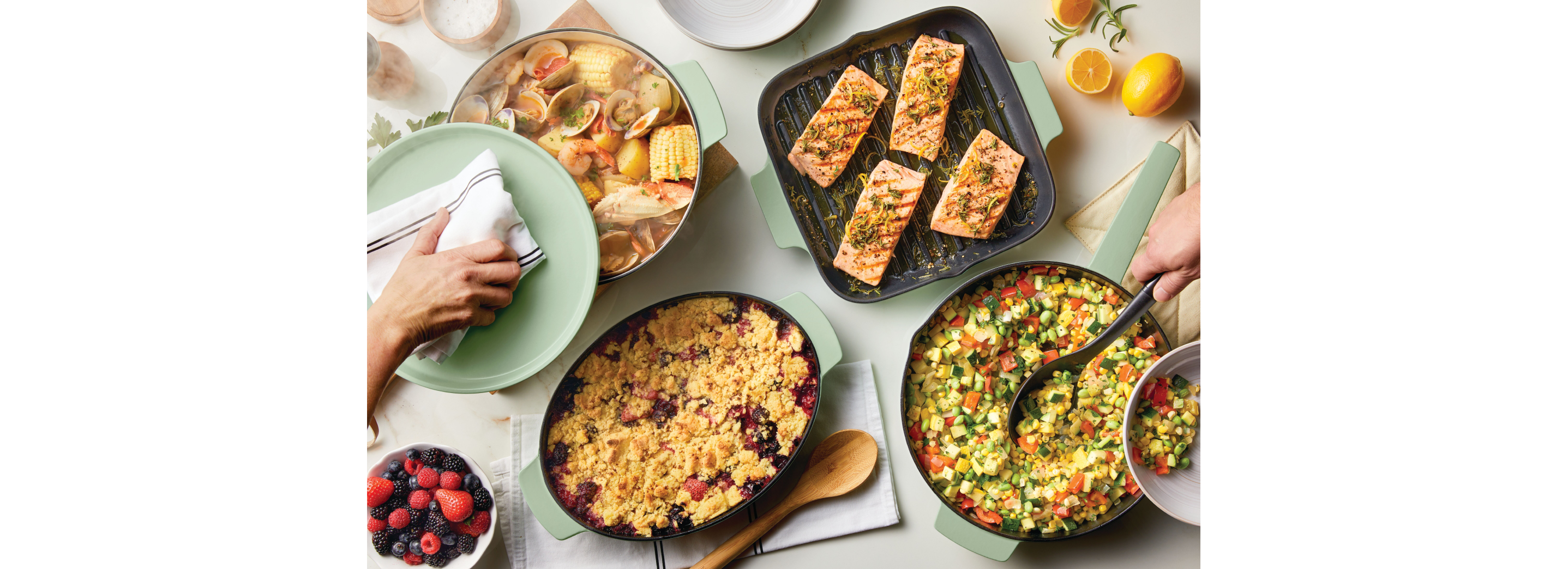 Different cast iron cookware serving an assortment of prepared dishes. 