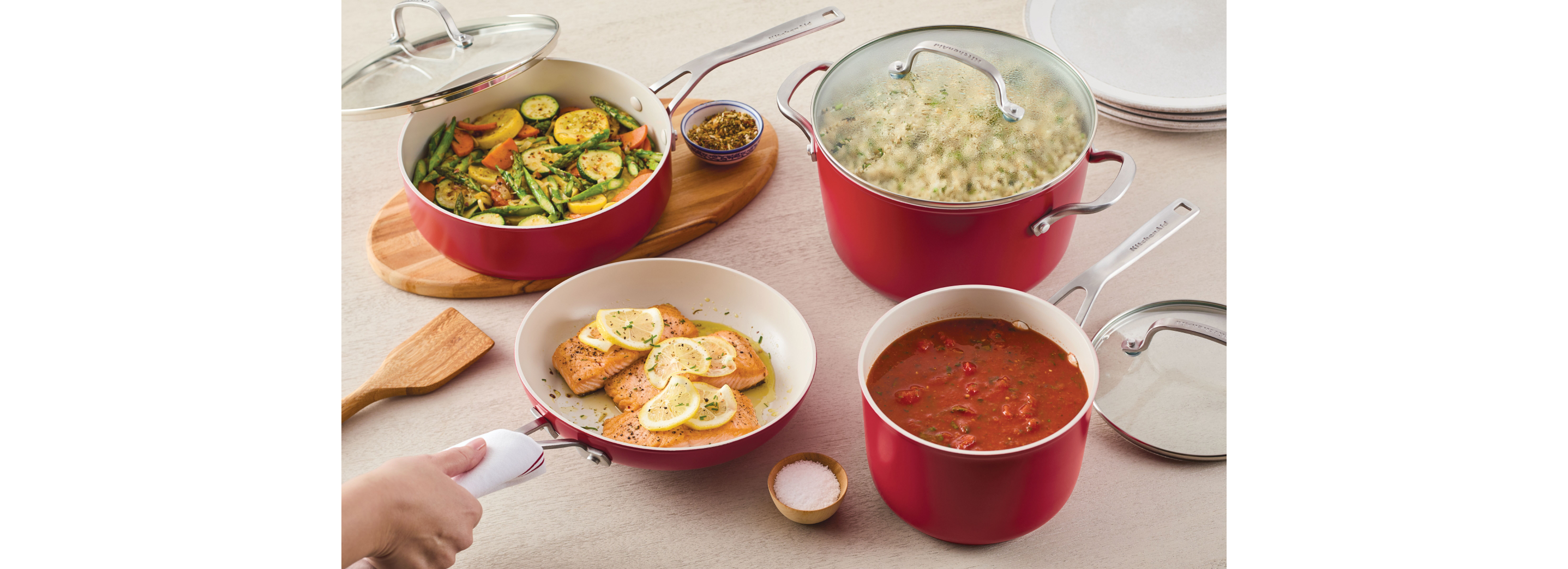 Various dishes in red ceramic forged aluminum cookware.