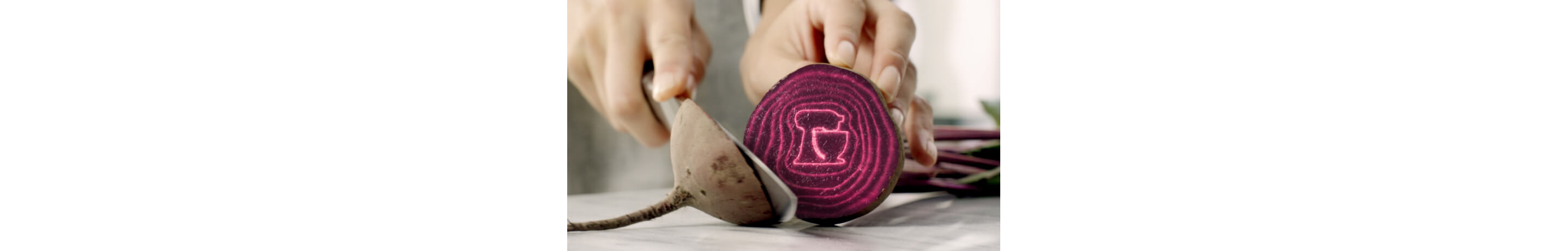 A person cutting into a beetroot.