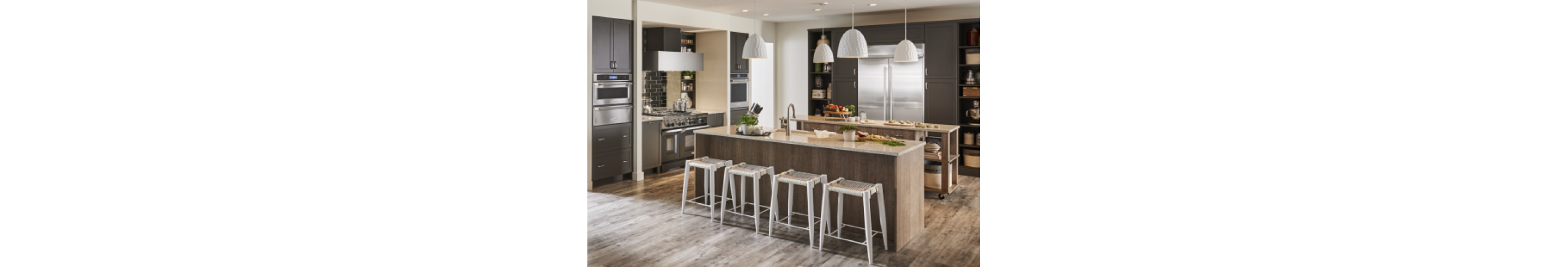 A modern kitchen with dark cabinetry and KitchenAid stainless steel appliances